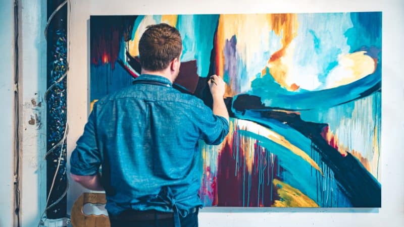 Un homme qui fait de petites corrections sur sa nouvelle peinture acrylique