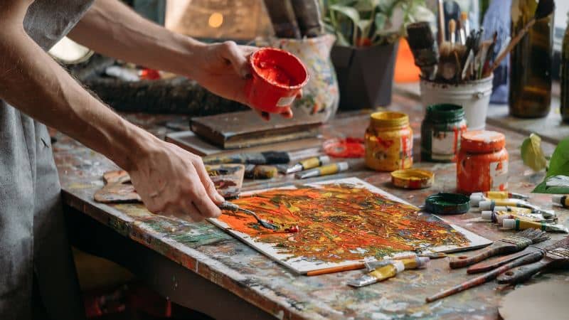 Un peintre abstrait qui teste différentes techniques de peinture
