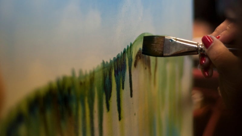Un peintre en train de finaliser une peinture acrylique