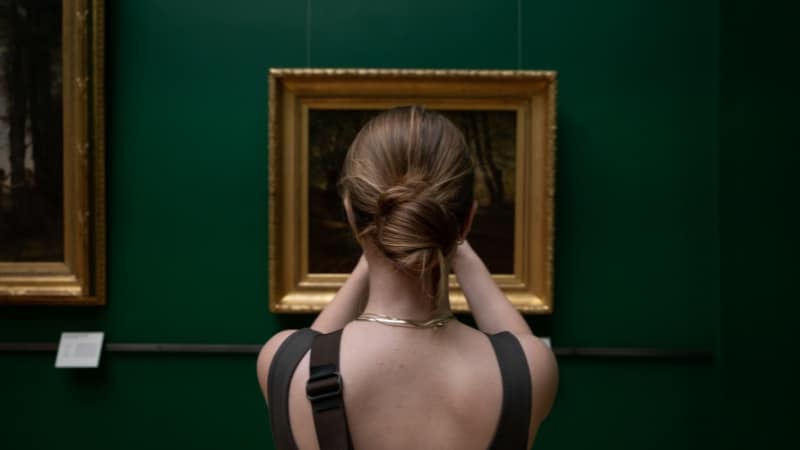 Une amatrice d'œuvre d'art qui examine une peinture