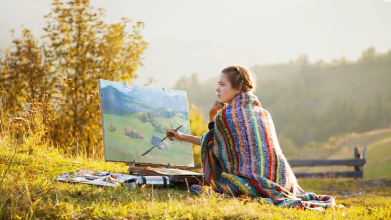 Une femme en train de peindre un paysage