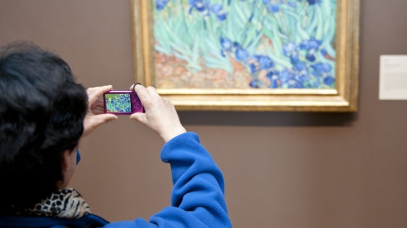 Une femme qui essaye d'apprendre le langage scriptural en visitant un musée