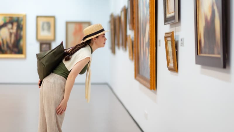 Une femme qui essaye de déterminer le contexte historique et culturel d'un tableau