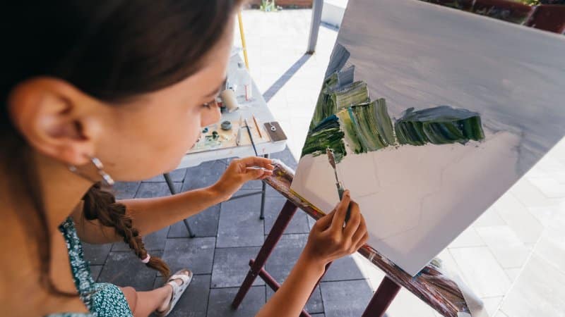 Une peintre abstraite qui peint avec une spatule