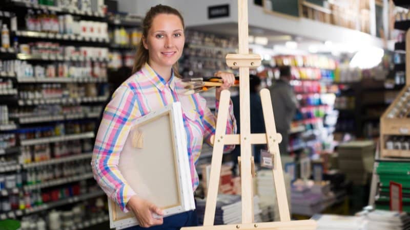 Une peintre débutante qui vient d'acheter une toile et un chevalet pour la peinture abstraite