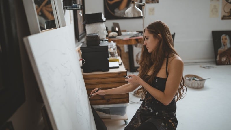 Une peintre qui dessine l'esquisse de sa peinture