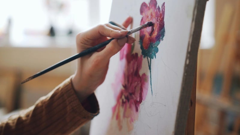 Une peintre qui pose les premières couches d'une peinture acrylique